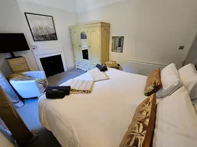 a bedroom with two beds and a fireplace at Harbour View - Luxury Town Centre Property in Rothesay
