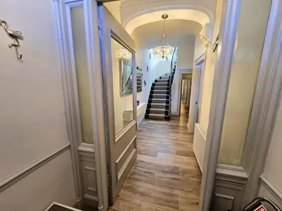 a hallway of a home with a staircase and a chandelier at Harbour View - Luxury Town Centre Property in Rothesay