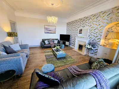 a living room with two couches and a fireplace at Harbour View - Luxury Town Centre Property in Rothesay