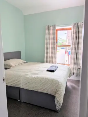 a bedroom with a large bed with a window at Argyll Place in Campbeltown