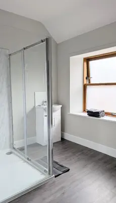a glass shower in a room with a window at Argyll Place in Campbeltown