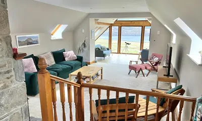 a living room with a couch and a table at Coach House at Morenish Mews in Killin