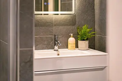 a bathroom sink with a mirror and a bottle of soap at Gleneagles Hideaway