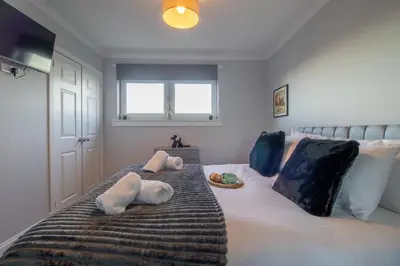 a bedroom with a bed with two stuffed animals on it at Raeburn House- 3 Bedrooms, 2 Bathrooms in Hamilton in High Blantyre