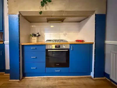 a kitchen with blue cabinets and a stove at Spacious Three Storey West End Home - 3 bedroom in Glasgow