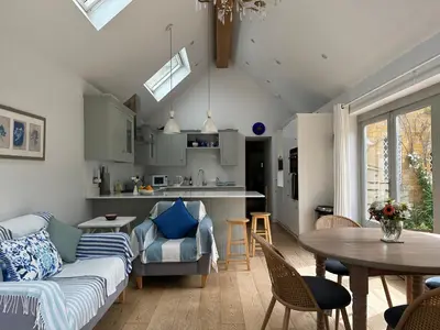 a living room with a couch and a table at Charming Cotswold stone cottage with garden in Moffat