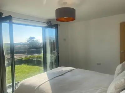 a bedroom with a bed and a large window at Tranquil Countryside Escape in Moffat