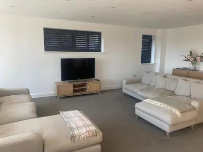 a living room with two couches and a flat screen tv at Tranquil Countryside Escape in Moffat
