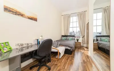 a room with a desk and a bedroom with a bed at 7 Bedroom Apartment - City Centre in Glasgow
