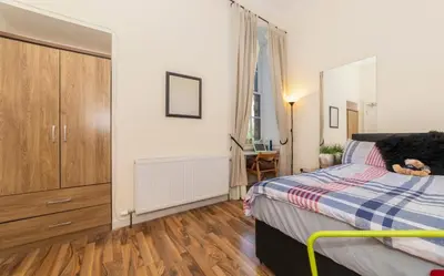 a bedroom with a bed with a teddy bear on it at 7 Bedroom Apartment - City Centre in Glasgow