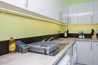 a kitchen with a dish drying rack on a sink at 7 Bedroom Apartment - City Centre in Glasgow