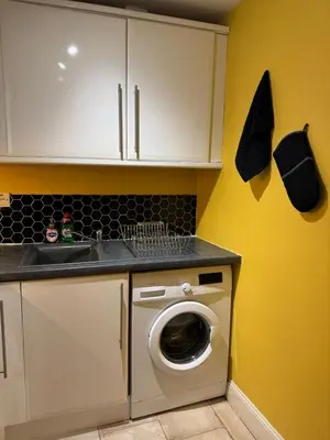 a kitchen with a washing machine and a sink at Auldhouse Apartment entire place 2 bedrooms in Mansewood