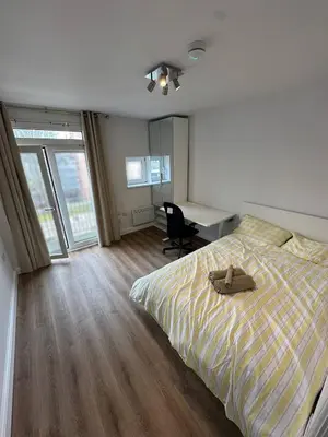 a bedroom with a bed and a desk with a chair at 3x Large Double bedroom, Central London flat in Moffat
