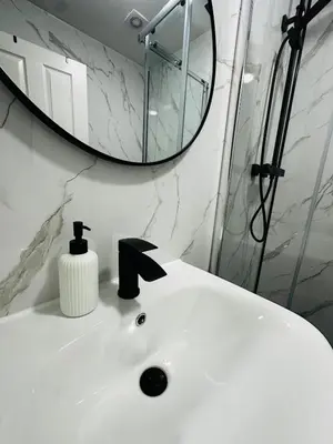 a bathroom with a white sink and a mirror at Modern 2 Bedroom Ground Floor Apartment near city centre in Glasgow