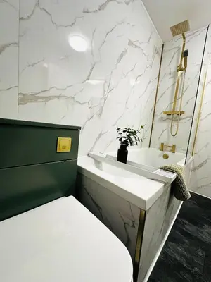 a bathroom with a white sink and a marble wall at Modern 2 Bedroom Ground Floor Apartment near city centre in Glasgow