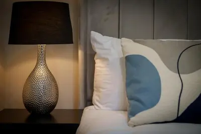 a lamp sitting on a table next to a bed at 3BR Home Sleeps 6 Near Airport with Parking