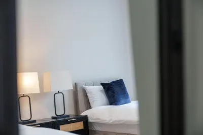a bedroom with a bed with two lamps and a mirror at 3BR Home Sleeps 6 Near Airport with Parking