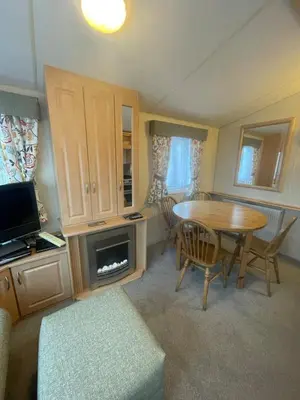 a small living room with a table and a tv at Cruachan View Caravan Farm stay in Oban
