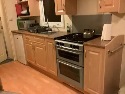 a kitchen with a stove and wooden cabinets at Cruachan View Caravan Farm stay in Oban