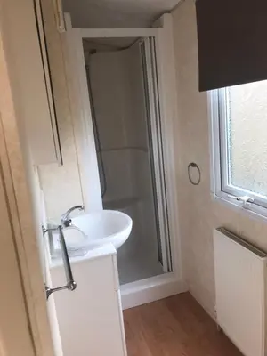 a bathroom with a white sink and a shower at Cruachan View Caravan Farm stay in Oban