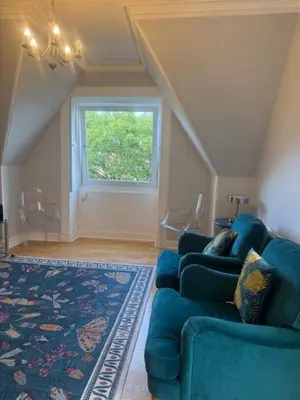 a living room with a blue couch and a window at Murrayfield Executive Apartment in Edinburgh