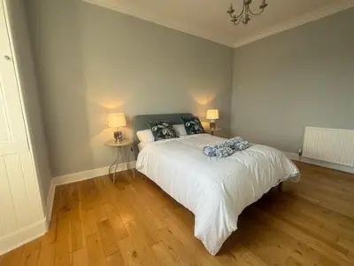 a bedroom with a white bed and two lamps at Murrayfield Executive Apartment in Edinburgh