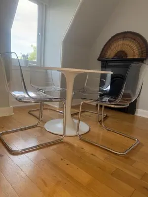 a table and chairs in a room with a fireplace at Murrayfield Gem in Edinburgh