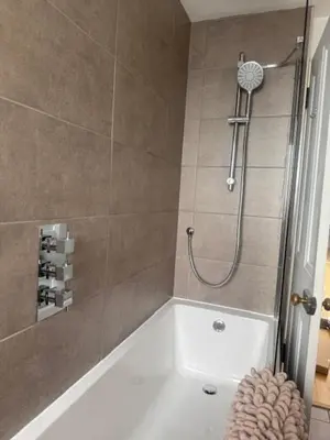 a bathroom with a shower with a white tub at Murrayfield Gem in Edinburgh