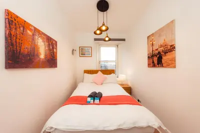 a bedroom with a bed with two pictures on the wall at Central Cosy Apartment by Meadows 6 in Edinburgh