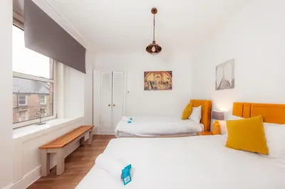 a bedroom with two beds and a window at Central Cosy Apartment by Meadows 6 in Edinburgh