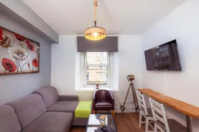 a living room with a couch and a table at Central Cosy Apartment by Meadows 6 in Edinburgh