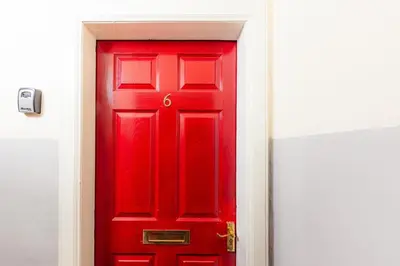 a red door with the number six on it at Central Cosy Apartment by Meadows 6 in Edinburgh