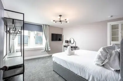 a white bedroom with a bed and a window at No8 Peebles Retreat - Donnini Apartments in Ayr