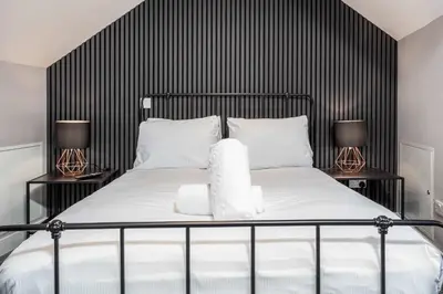 a bedroom with a black and white bed with two lamps at No8 Peebles Retreat - Donnini Apartments in Ayr