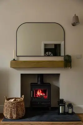a living room with a fireplace with a mirror at Cosy Callander One Bed Apartment Wood Burner and Free Parking in Callander