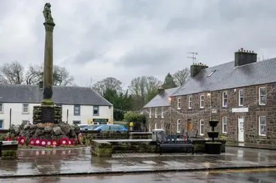a fountain in the middle of a town square with buildings at Cosy Callander One Bed Apartment Wood Burner and Free Parking in Callander