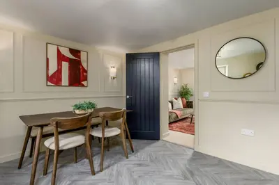 a dining room with a table and chairs and a mirror at The Bruces Quarter in Stirling