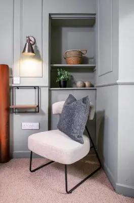a chair with a pillow on it in a room at Caledonia Suite by The Wallace Monument in Stirling