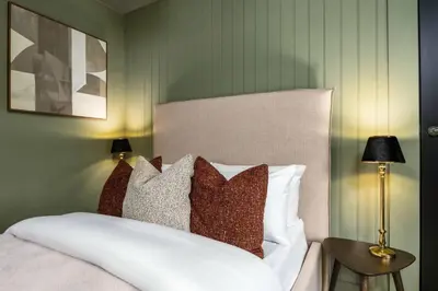 a bedroom with a white bed with pillows at The Wallace Suite by The Wallace Monument in Stirling