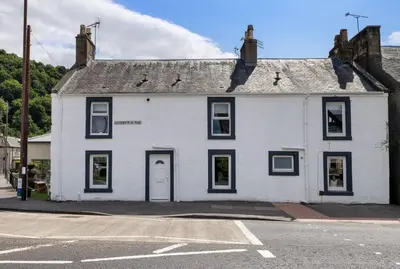 a white house with black windows on a street at The Wallace Suite by The Wallace Monument in Stirling
