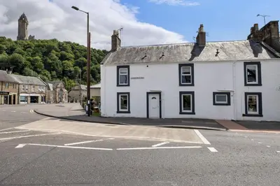 a white building on the corner of a street at The Wallace Suite by The Wallace Monument in Stirling