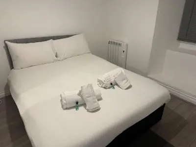 a white bed with towels on top of it at West End Stay by Kelvingrove in Glasgow