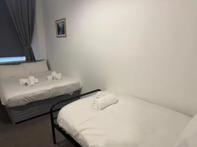a room with two beds with towels on them at West End Stay by Kelvingrove in Glasgow