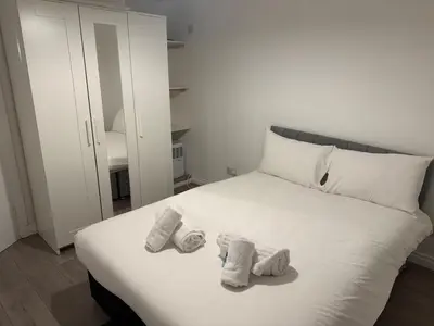 a white bed with two pairs of socks on it at West End Stay by Kelvingrove in Glasgow