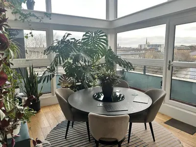 a table and chairs in a room with windows at Duplex Penthouse with Secured Parking Finnieston in Glasgow