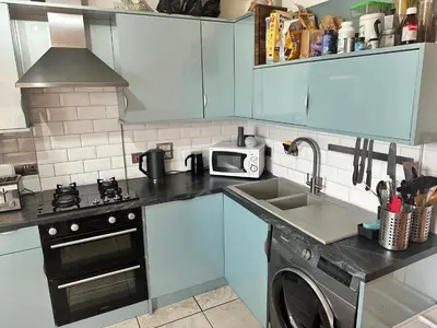 a kitchen with a sink and a stove and a microwave at Duplex Penthouse with Secured Parking Finnieston in Glasgow