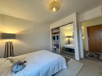 a bedroom with a bed and a large mirror at Duplex Penthouse with Secured Parking Finnieston in Glasgow