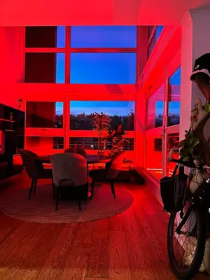 a dining room with red lighting and a table and chairs at Duplex Penthouse with Secured Parking Finnieston in Glasgow