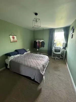 a bedroom with a bed and a window and a chair at Duplex Penthouse with Secured Parking Finnieston in Glasgow