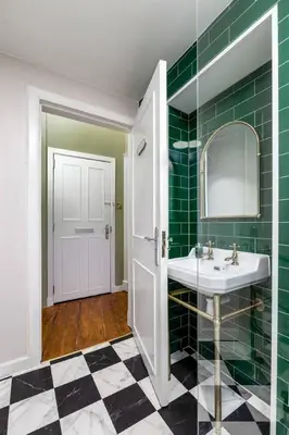 a bathroom with a sink and a mirror and green tiles at Elegant 3 Bed Apartment in Stirling Near Free Parking and Hill Views in Stirling